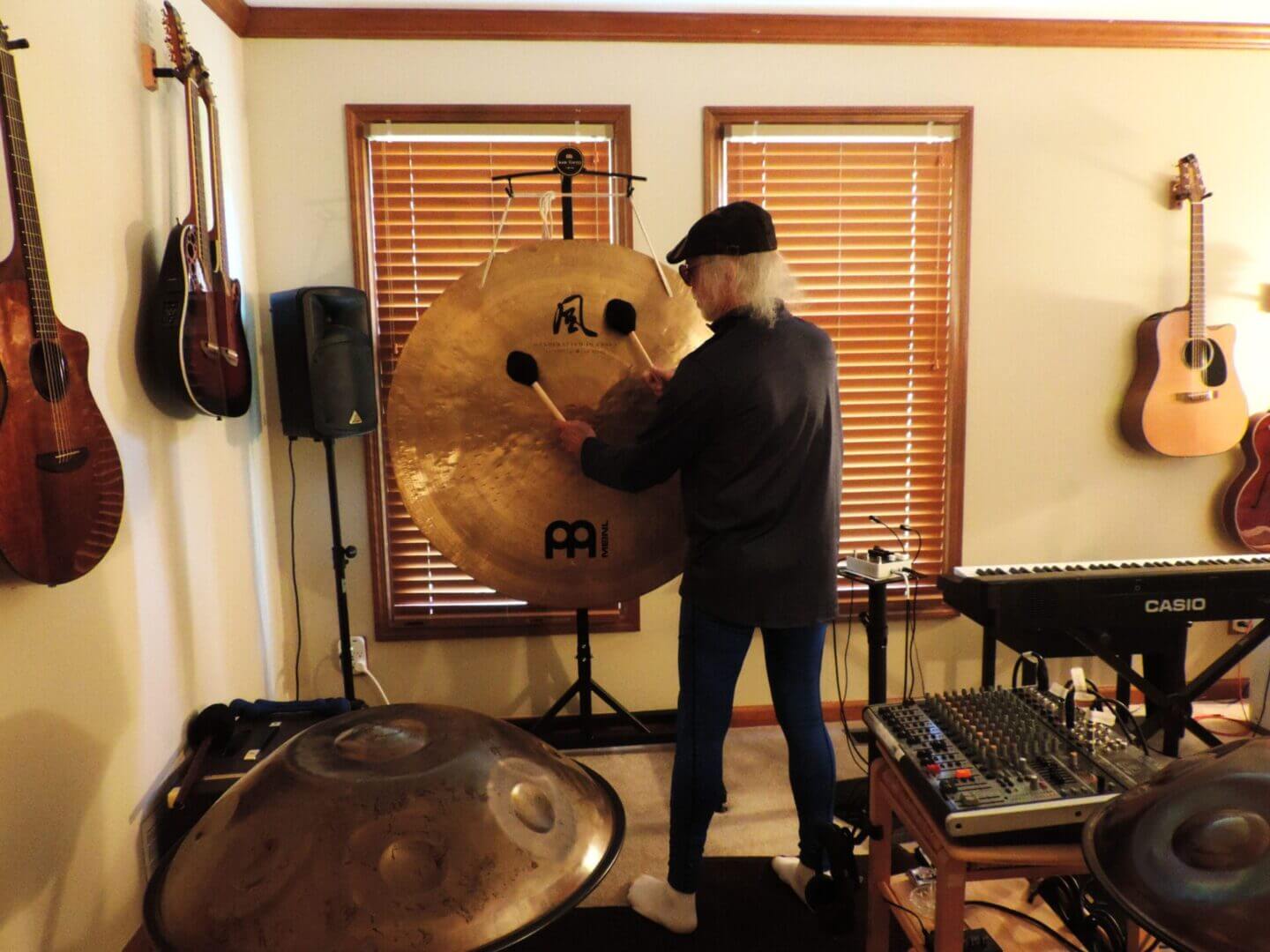 Person playing a large gong in a music room.