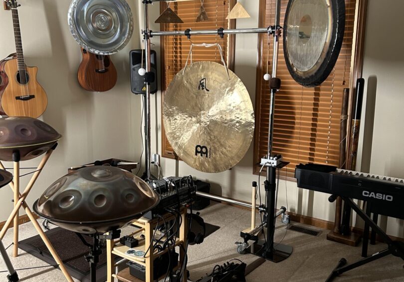 Room with gongs, handpans, and guitars